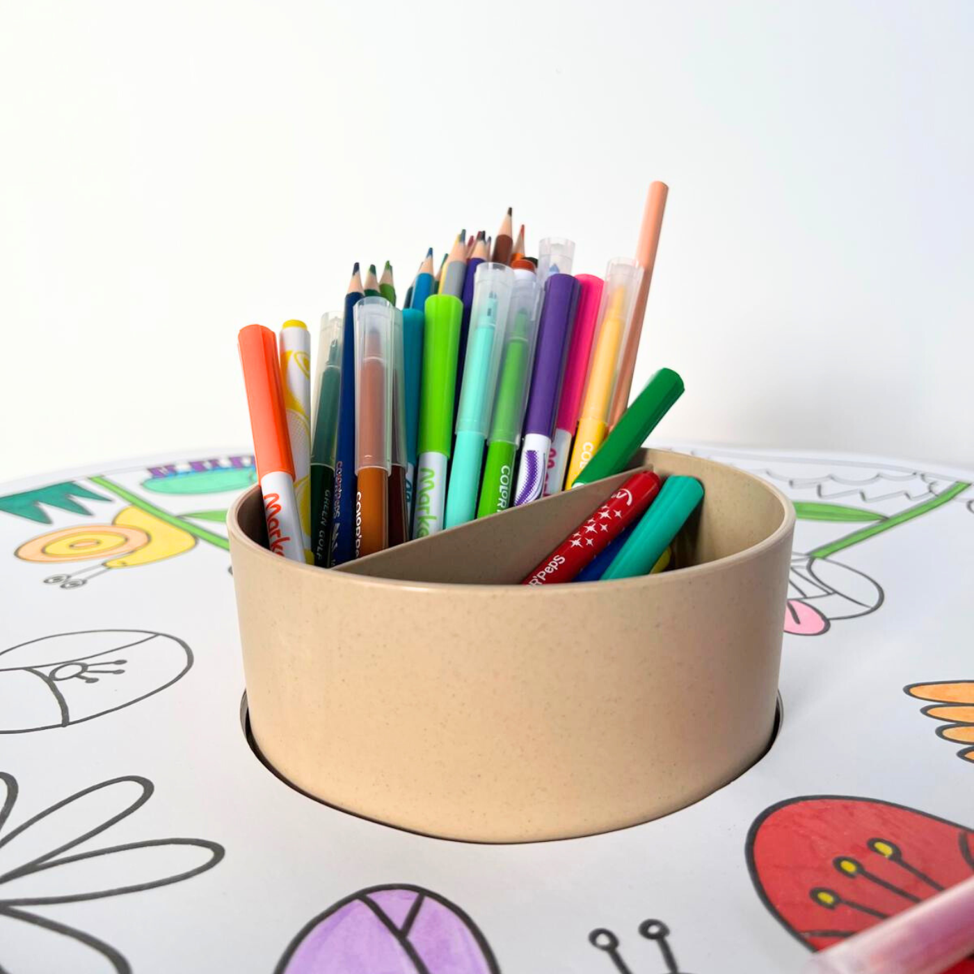 Colourful pens and pencils in a holder.