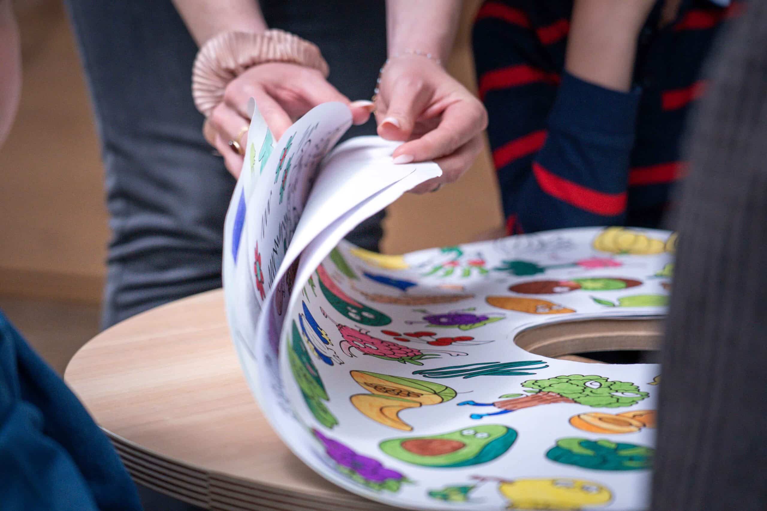 Un adulte compte les feuilles de coloriage de la Drawin'table