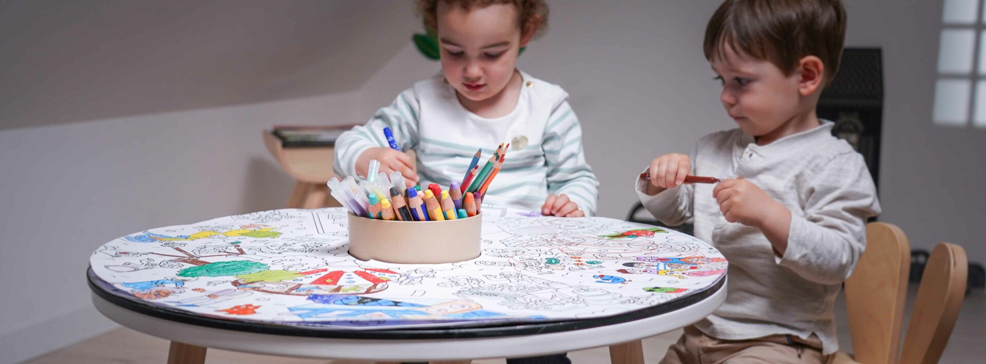 Deux enfants occupés à dessiner sur une table d’activité sans écran