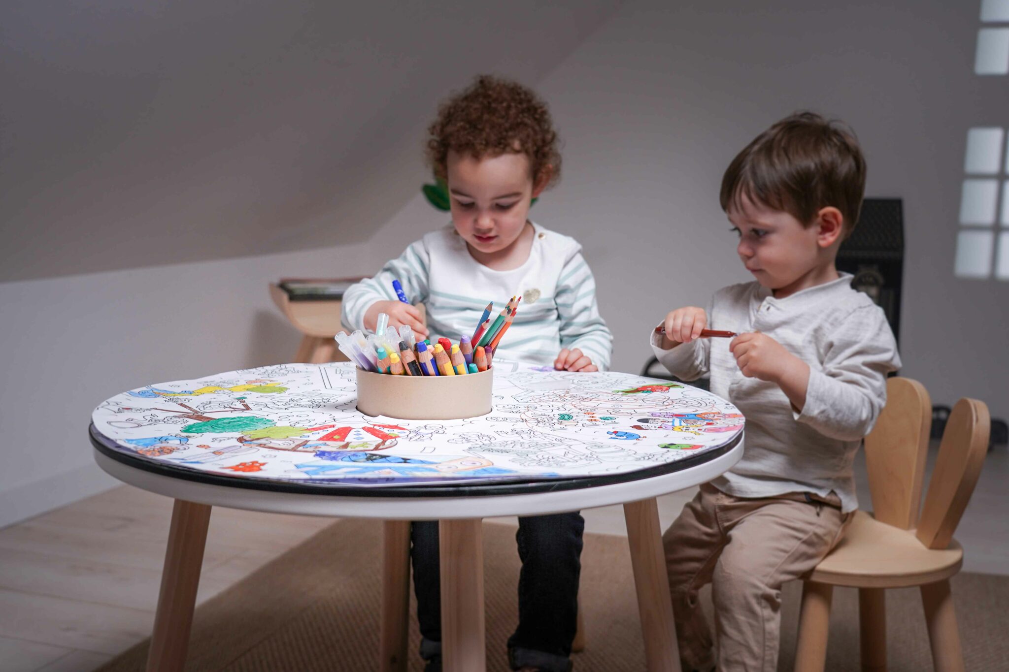 Deux enfants coloriant ensemble un coloriage géant sur une table Drawin’kids
