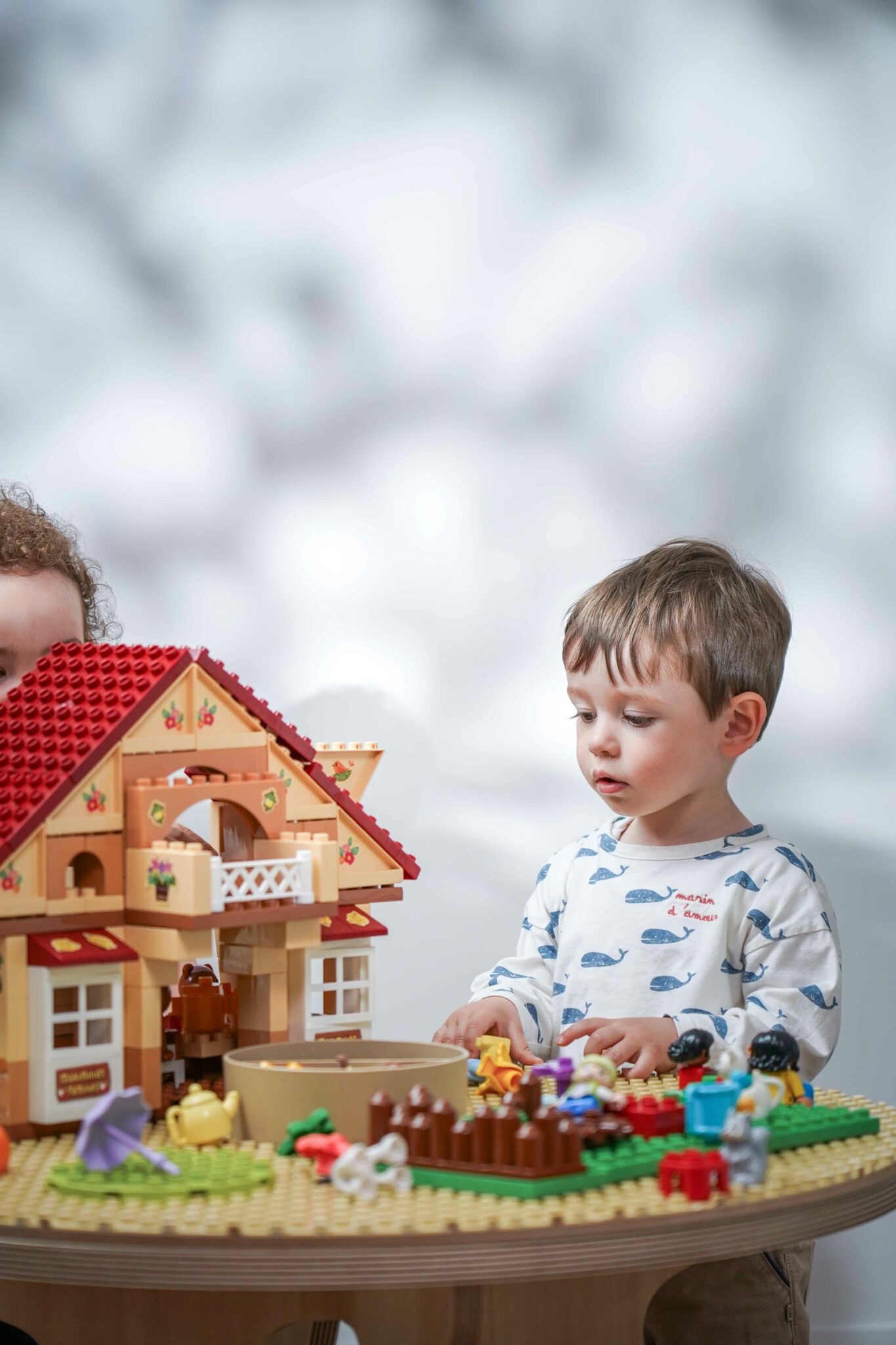 Enfant jouant avec des briques de construction sur une table d’activités Drawin’kids