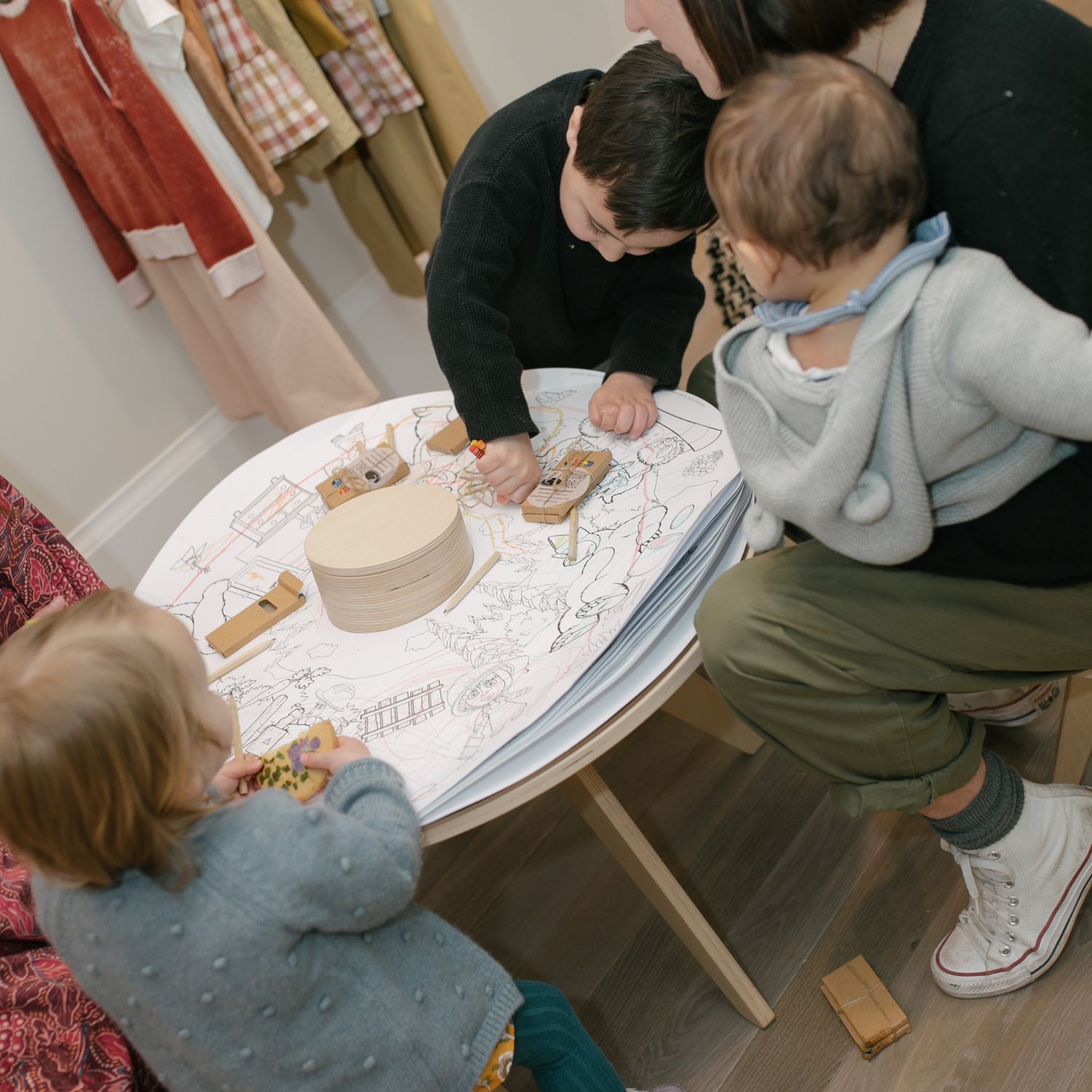 Enfants coloriant autour d’une table avec adulte
