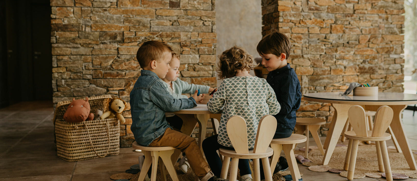 Quatre enfants jouent autour d’une petite table