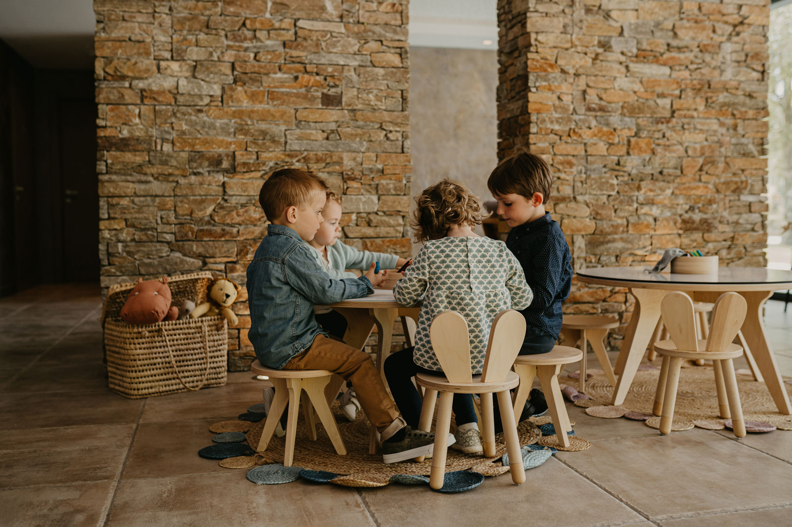 Quatre enfants jouent autour d’une petite table