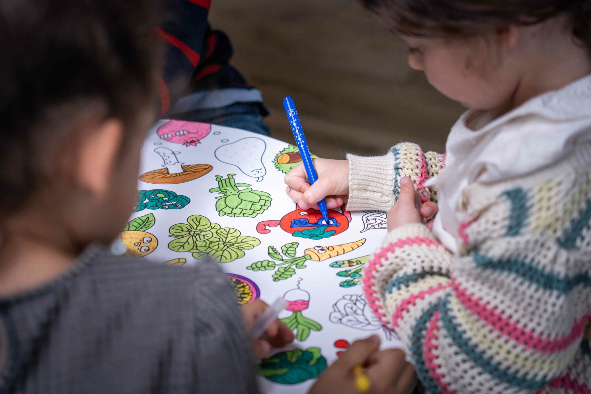 Enfants coloriant ensemble sur une table de coloriage Drawin’kids