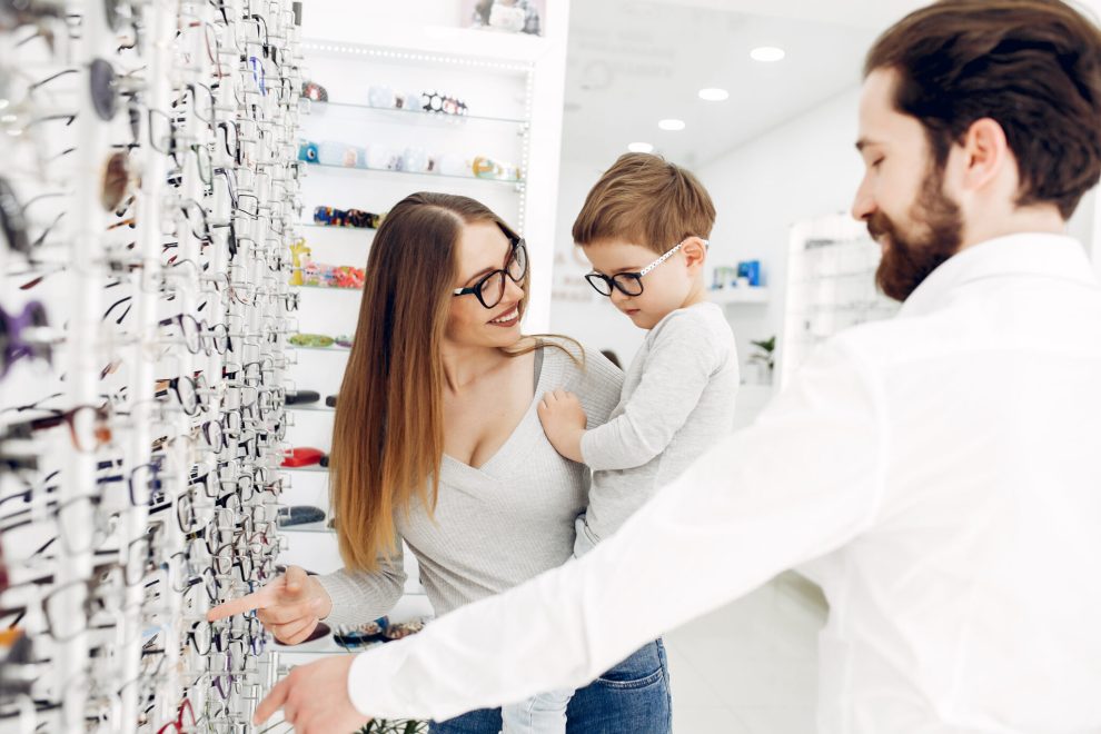 Famille choisissant des lunettes dans un magasin d'optique.