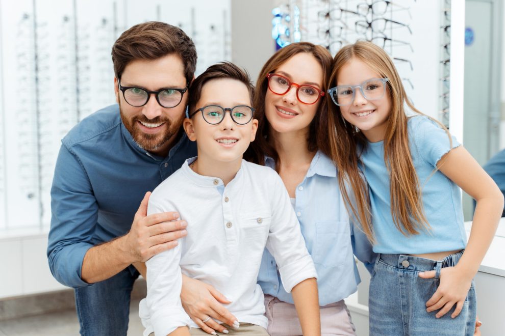 happy family choosing glasses while posing in optics espace jeux enfants opticien